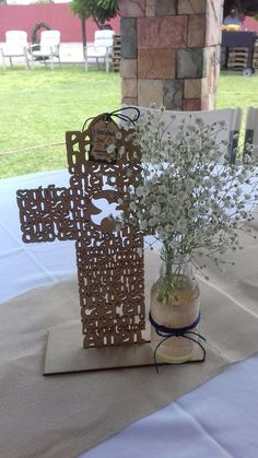 a vase filled with flowers sitting on top of a white table cloth covered tablecloth