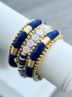 the bracelets are stacked on top of each other with gold and blue beading