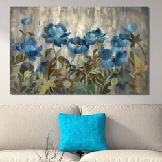 a painting on the wall above a couch in a living room with blue flowers and leaves