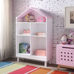 a child's room with a pink bookcase and white brick wall behind it