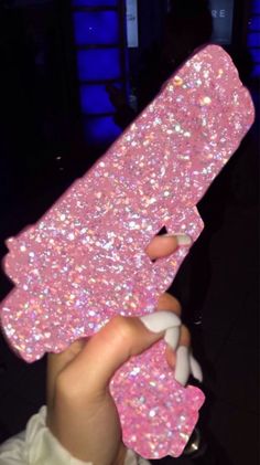 a person holding up a pink phone case with glitter on the back and white trim