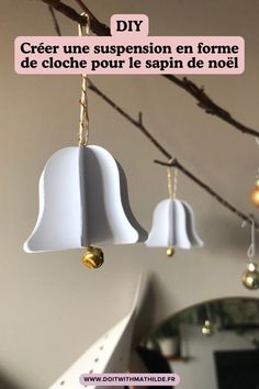 three bells hanging from a tree branch with the words diy in french above them