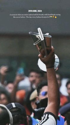 a man holding up a trophy in the air with his fist raised above his head