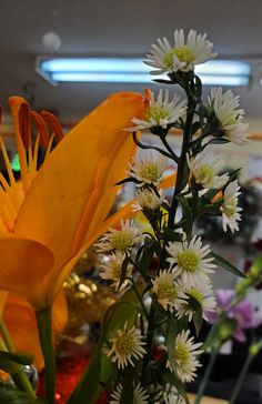 a vase filled with white and yellow flowers