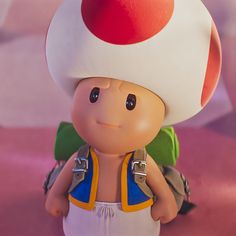 a close up of a toy with a mushroom on it's head and backpack