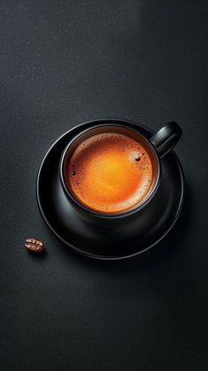 a cup of coffee on a saucer next to some nuts