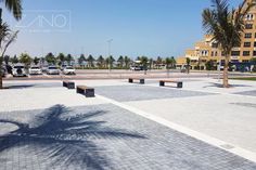 an empty parking lot with benches and palm trees