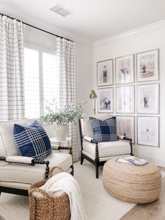 a living room with white furniture and blue pillows on the couches in front of windows