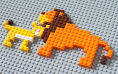 an orange and brown pixellated object on top of a white surface with legos