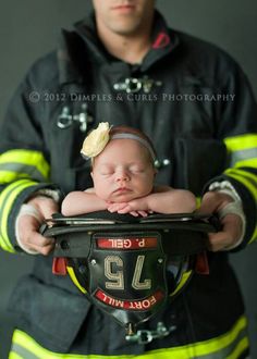 a firefighter holding a newborn baby in his arms