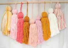 multicolored yarn tassels hanging on a wall