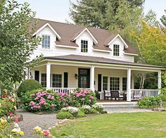 a white house with flowers in the front yard