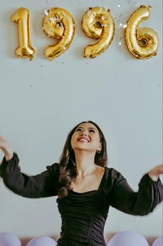 a woman standing in front of balloons and numbers