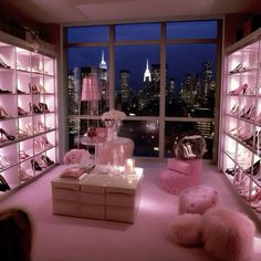 a room filled with lots of pink furniture and high rise buildings in the background at night