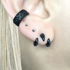 a close up of a person's ear with black beads