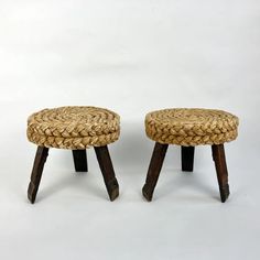 two small stools made out of wood and woven material, one with wooden legs