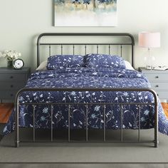 a bedroom with a metal bed frame and blue bedspread on the floor next to two nightstands