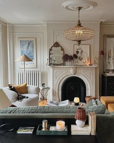 a living room filled with furniture and a fire place under a chandelier above a fireplace