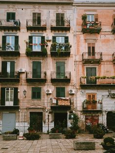 an old building with many balconies and plants on the balconys in front of it