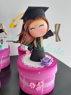 a cake that has a girl in a graduation outfit on it