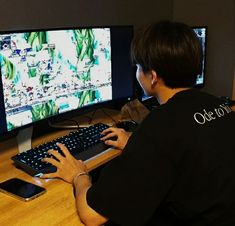 a person sitting at a desk with a keyboard and mouse in front of two monitors