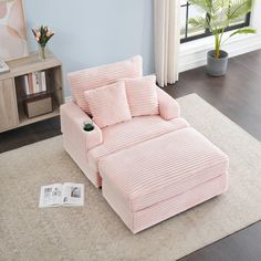 a pink corded couch with pillows on it in front of a blue wall and window