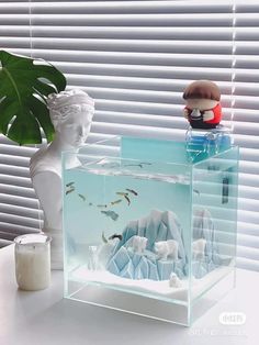 a fish tank sitting on top of a table next to a vase