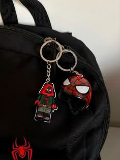 a spiderman backpack with two key chains attached to it