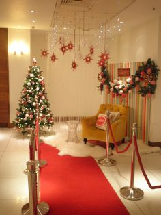 a room decorated for christmas with red carpet and decorations