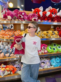 a woman is standing in front of shelves with stuffed animals on display at a toy store