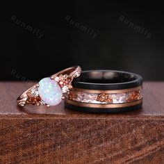 two wedding rings with opal and diamond accents on top of a wooden box,