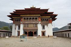 an old building in the middle of a desert area with mountains in the back ground