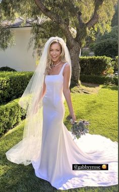 a woman in a wedding dress is walking through the grass