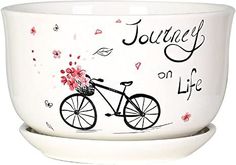 a white bowl with a bicycle painted on the side and words that read, journey on life