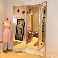 a mannequin is standing in front of an open closet with dresses on display