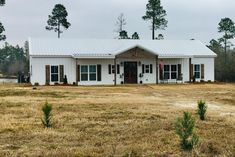 a small white house in the middle of a field