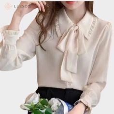 Indulge in luxurious elegance with this exquisite ribbon bow blouse. Constructed with delicate chiffon, this top features a draped lapel and a charming ribbon bow for added sophistication. Perfect for any occasion, elevate your style with this premium top. Attention! Sizes: In some cases, our clothing sizes may be Asian size, not US/European size. As a result, garments may run 1-2 sizes smaller than your usual size so please ensure that you have reviewed the sizing chart to confirm your specific measurements before your purchase to prevent unnecessary return of goods. Color Variation: While we aim to always provide you with the most accurate product descriptions and pictures possible, please understand that the actual color may differ slightly from the pictures shown online (due to the eff Feminine Tie Neck Blouse With Bow, Feminine Party Blouse With Bow, Feminine Office Tops With Bow Detail, Elegant Tie Neck Blouse For Semi-formal Occasions, Elegant Tie Neck Blouse For Semi-formal Events, Elegant Semi-formal Tie Neck Blouse, Elegant Chiffon Top For Office Wear, Elegant Chiffon Blouse With Ruffled Collar, Elegant Tops With Bow For Workwear