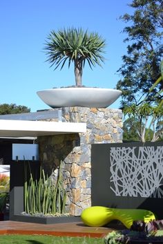 a modern house with an unusual planter in the front yard