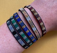 a woman's arm with four different bracelets on top of each other,