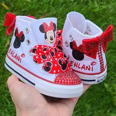 White high top Converse with red crystals on toes and backs, red shiny bows on backs. Minnie Mouse on the tongues and laces just as shown. Your little ones name will be done in glittery red on the sides with the Minnie head on both shoes. Minnie Mouse Converse, Minnie Shoes, Custom Baby Shoes, Minnie Mouse Birthday Party Decorations, Minnie Mouse Shoes, White High Top Converse, Bling Converse, Minnie Mouse 1st Birthday, Black Slip On Sneakers