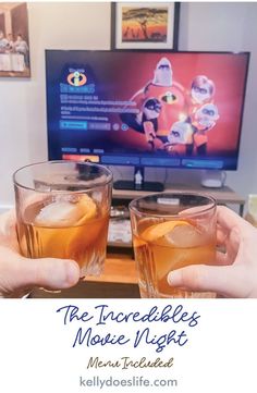 two people holding up glasses with drinks in front of a flat screen tv that reads the incredible bees movie night