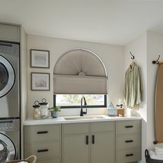 a washer and dryer in a room with pictures on the wall above them