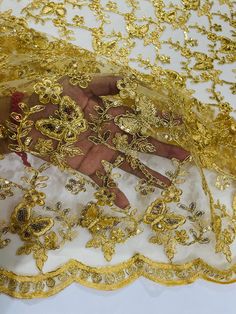 a woman's hand is covered with gold sequins on a white surface