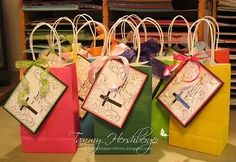 four small bags with designs on them are sitting in front of a rack full of clothes