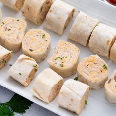 several different types of food on a white platter next to tomatoes and parsley