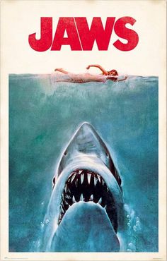 a movie poster for jaws with a shark in the water and a man swimming behind it