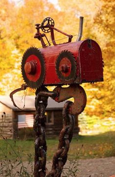 an old fashioned red tractor with chains attached to it