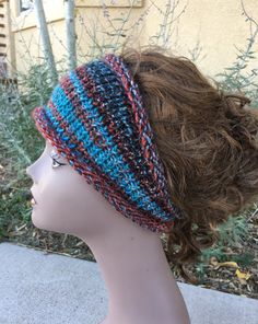 a woman's head wearing a multicolored knitted beanie on top of a mannequin