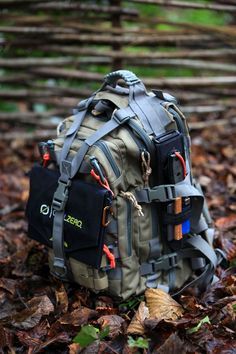 a backpack sitting on the ground surrounded by leaves