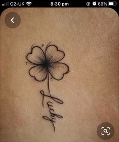 a small tattoo on the back of a woman's stomach with a four leaf clover